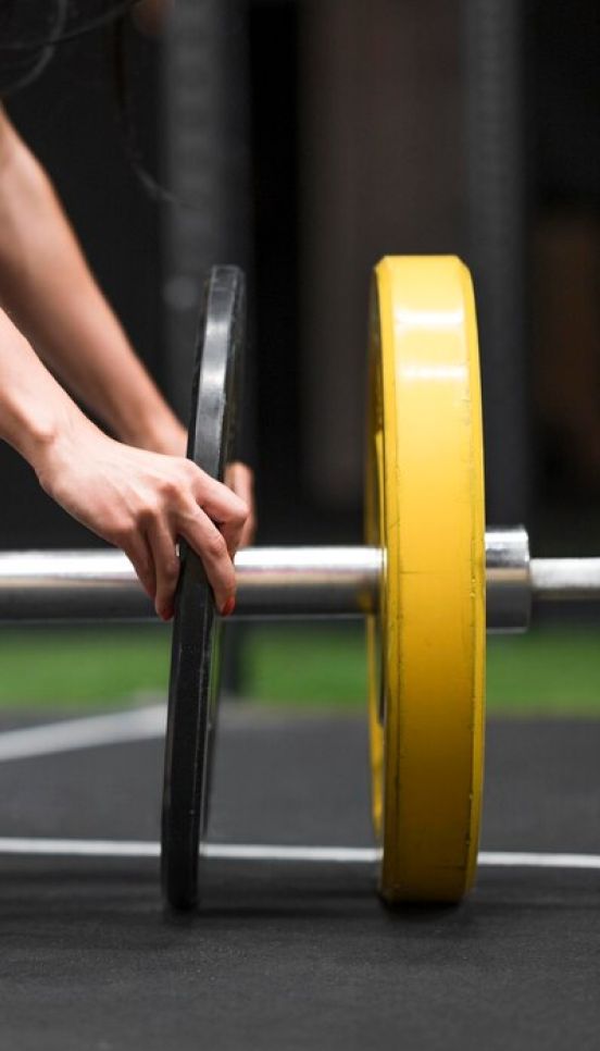 Person-Adding-A-Weight-To-A-Barbell